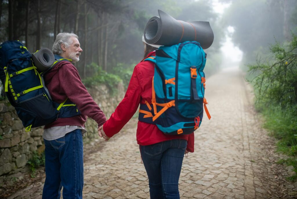 Sophie et Louis souriant, main dans la main, au pied des montagnes