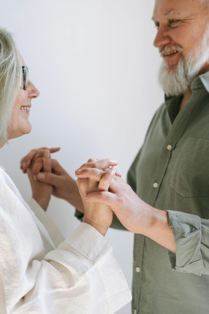 couple de plus de 50 ans main dans la main, regardant amoureusement l'un l'autre avec complicité et amour