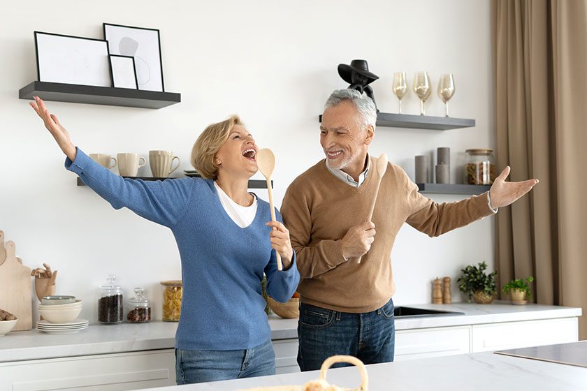 couple senior cuisinant ensemble dans une cuisine, représentant la joie de partager des passions comme la cuisine pour renforcer les relations et créer des moments agréables à deux