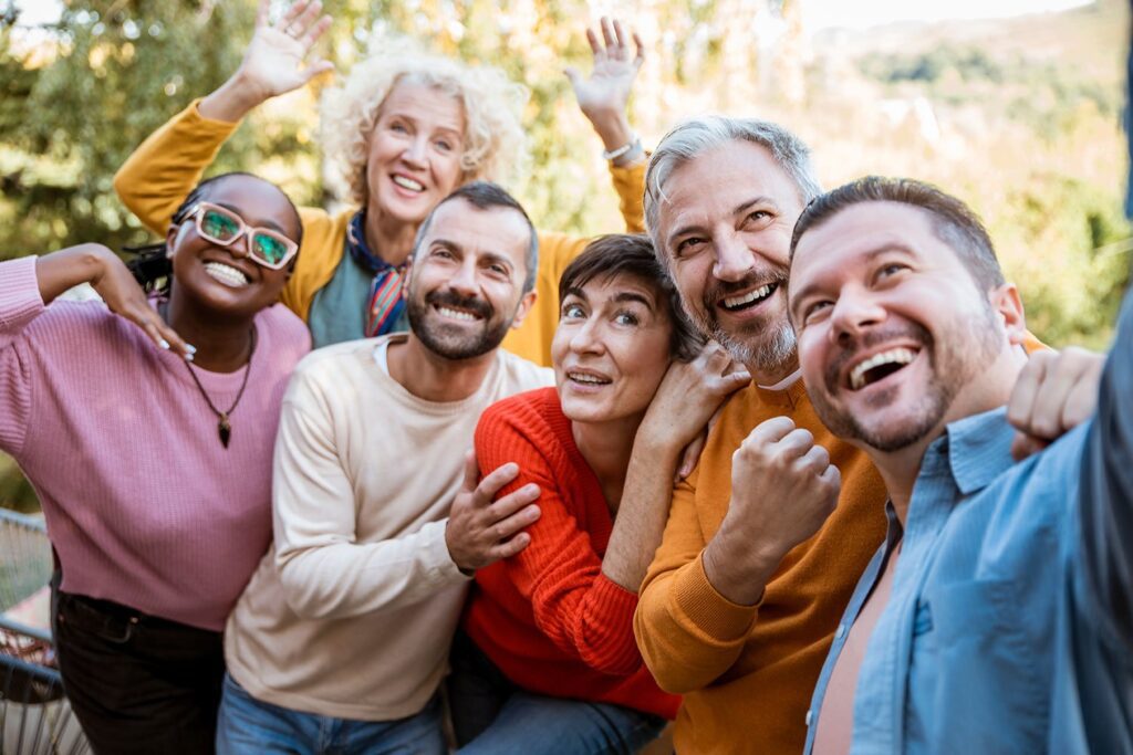 groupe de seniors souriants prenant une photo ensemble lors d'une sortie conviviale